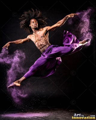 Bare chested in purple pants, a man leaps through clouds of violet powder in a dark room