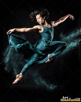 Leaping midair with teal powder, a man in a flowing teal dress dances against black