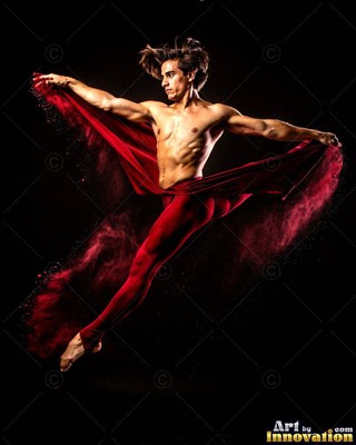 Man leaping through the dark while trailing red powder