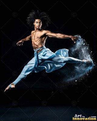 A shirtless man leaps in blue pants while throwing white powder