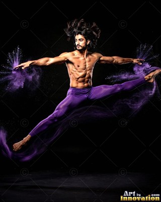 A shirtless man leaps in a split kick, scattering clouds of purple powder against the dark