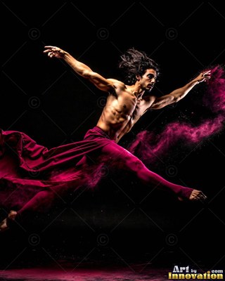 A shirtless man leaps across a dark space trailing pink fabric and powder