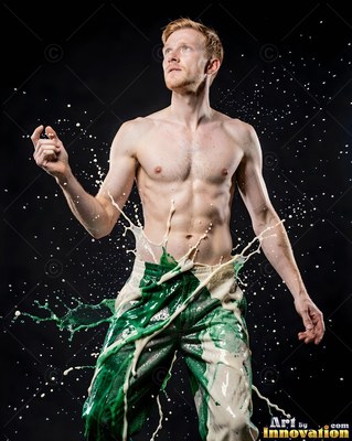 A shirtless man looks up as splashes of white and green liquid hit his trousers