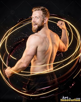A shirtless bearded man flexing his back inside bright yellow light trails