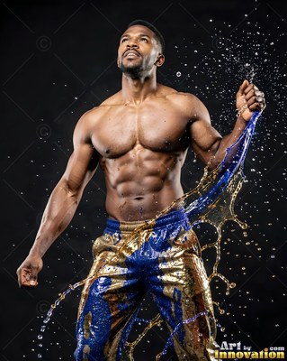 In a dark studio, a muscular man stands splashed with blue and gold liquid