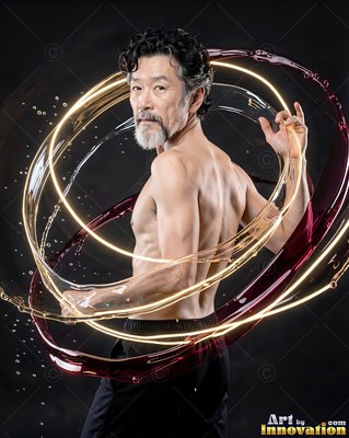 Gray-bearded shirtless man standing in a dark studio wrapped in rings of red liquid and light