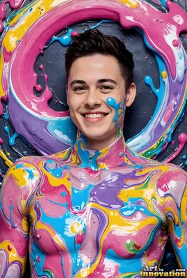 In a studio, a smiling man stands covered in swirls of pink, blue, and yellow paint