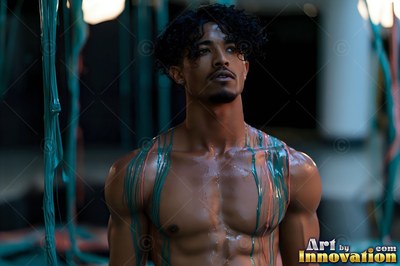 A shirtless man stands looking up with green paint dripping down his chest