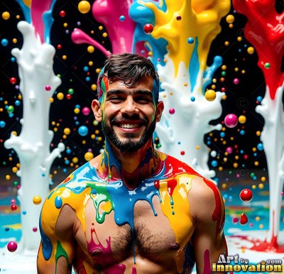 In front of paint splashes, a smiling shirtless man is coated in yellow and blue