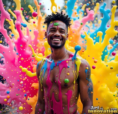 Facing forward outside, a smiling bare-chested man covered in pink and yellow paint splatters