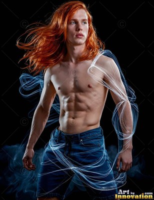 Long red hair blows around a shirtless young man wrapped in loops of white light on black