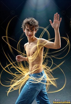 Bare-chested in blue jeans, a young man poses in a dark studio circled by loops of gold light