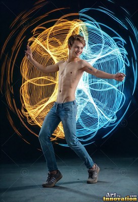 A man without a shirt dances before circles of blue and gold light
