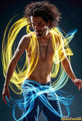 A bare-chested man looks down while swirls of yellow and bright blue light curl around his body