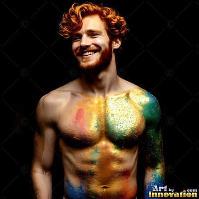 A smiling red-haired shirtless man standing against black with gold and teal powder on his chest