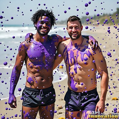 Two grinning shirtless men covered in purple paint on a sunny beach