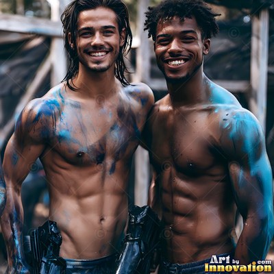 Outdoors, two shirtless smiling men stand covered in bright blue paint splatters