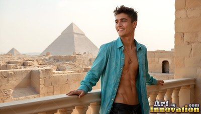 A smiling young adult man with an open dark teal shirt stands on a balcony by the pyramids