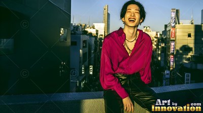 Laughing in the sun, a young man wears a magenta shirt on a Tokyo rooftop