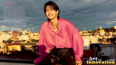 Smiling man sits on a rooftop in tokyo at sundown in a bright pink silk shirt