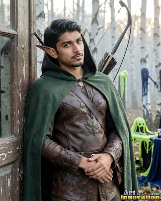 Man dressed as an elf archer in a green cloak outdoors