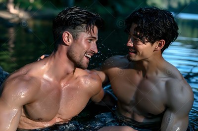 Two shirtless men smile at each other in lake water
