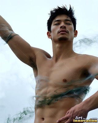 A shirtless man raises his arm outside as green smoke curls across his bare chest