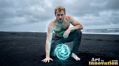 A shirtless man kneels on dark sand, conjuring a swirl of bright blue water