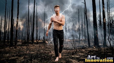 Barefoot shirtless man walks through burned woods with white lightning