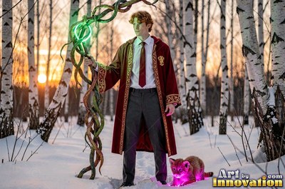 A man in a red wizard robe stands in a snowy birch forest holding a staff