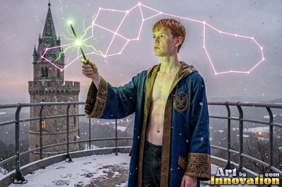 A young man in a pale blue robe holds a wand on a snowy tower roof
