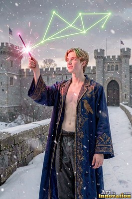 Young blond man in an open blue robe holding a wand in snow