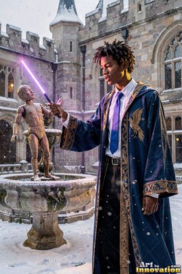 Young man in a blue robe points a purple wand in the snow