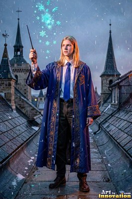 A blond man raises a wand on a rooftop in a blue robe under bright turquoise sparks