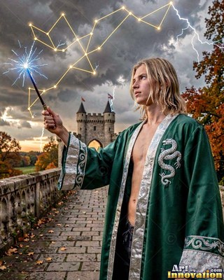 Blond man dressed in an unbuttoned green robe holds a wand on a bridge