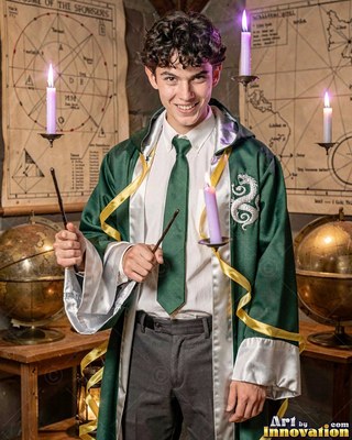 A smiling man dressed in a green snake robe holds two wands near floating candles
