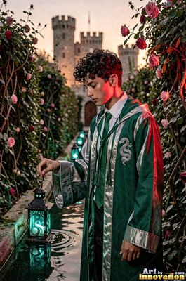 A young man grasps a green lantern over shallow water in soft evening light