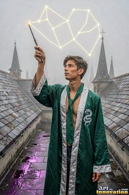 Raising a wand on a wet rooftop, a young man draws bright lines in a green robe