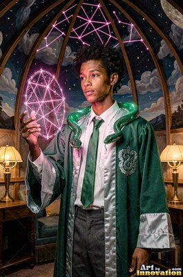 A young man holds up a pink light shape with a bright green snake on his shoulders