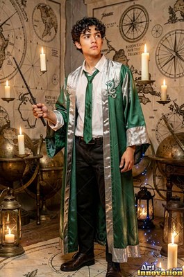 Holding a wand, a young man stands in a loose green robe surrounded by floating candles