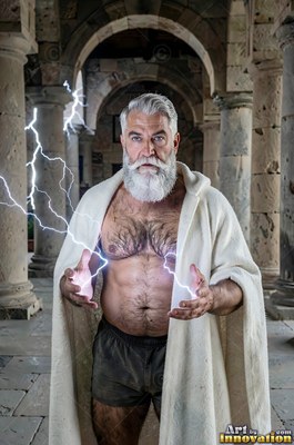 A bearded older man in a white cloak holds lightning in stone ruins