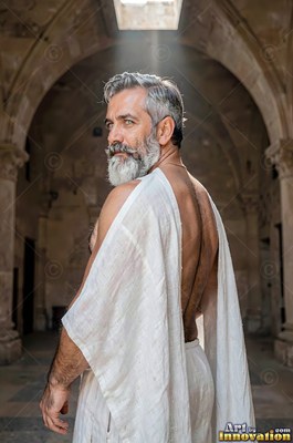 Under a stone arch, a gray-bearded man dressed in a white toga looks back over his shoulder