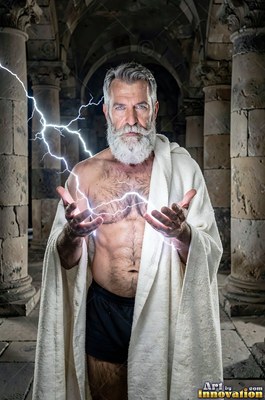 Holding lightning between his hands, an older man who has a beard stands in a stone hall