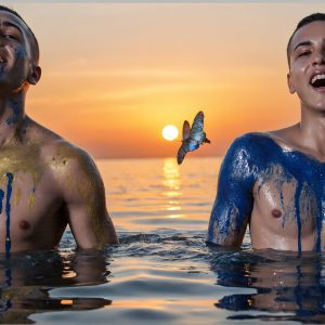 The Beautiful & Handsome Men Art Collection, A high-resolution photograph of two handsome best friends, half submerged in water, covered in body paint. Butterfly's flying about, as they spend time together, with a smile on their faces.