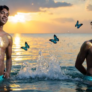 The Beautiful & Handsome Men Art Collection, A high-resolution photograph of two handsome best friends, half submerged in water, covered in body paint. Butterfly's flying about, as they spend time together, with a smile on their faces.