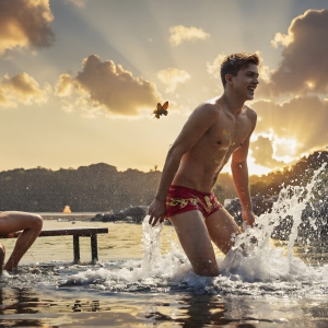 The Beautiful & Handsome Men Art Collection, A high-resolution photograph of two handsome best friends, half submerged in water, covered in body paint. Butterfly's flying about, as they spend time together, with a smile on their faces.