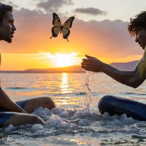 The Beautiful & Handsome Men Art Collection, A high-resolution photograph of two handsome best friends, half submerged in water, covered in body paint. Butterfly's flying about, as they spend time together, with a smile on their faces.