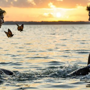 The Beautiful & Handsome Men Art Collection, A high-resolution photograph of two handsome best friends, half submerged in water, covered in body paint. Butterfly's flying about, as they spend time together, with a smile on their faces.