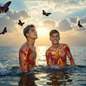 The Beautiful & Handsome Men Art Collection, A high-resolution photograph of two handsome best friends, half submerged in water, covered in body paint. Butterfly's flying about, as they spend time together, with a smile on their faces.