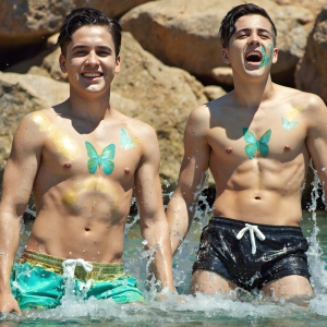The Beautiful & Handsome Men Art Collection, A high-resolution photograph of two handsome best friends, half submerged in water, covered in body paint. Butterfly's flying about, as they spend time together, with a smile on their faces.